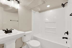 Full bathroom with a sink, bathtub / shower combination, and toilet