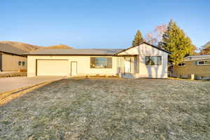 Ranch-style home with an attached garage, central AC, concrete driveway, and stucco siding