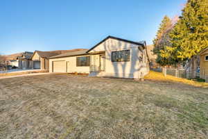 Ranch-style house featuring stucco siding, concrete driveway, fence, a garage, and a front lawn