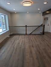 Spare room with a textured ceiling, recessed lighting, dark wood-type flooring, visible vents, and baseboards