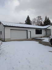 Snow covered garage featuring a garage