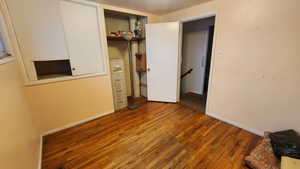 Unfurnished bedroom with baseboards and wood finished floors