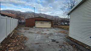 Detached garage featuring a mountain view, driveway, and fence