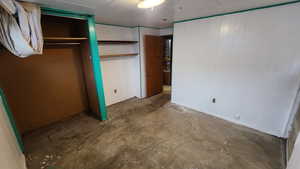 Unfurnished bedroom featuring unfinished concrete floors