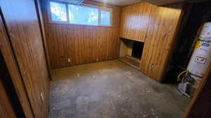 Basement featuring wooden walls and gas water heater