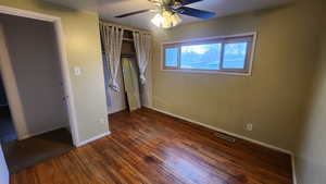 Unfurnished bedroom with baseboards, visible vents, a ceiling fan, dark wood-type flooring, and a closet