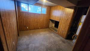 Basement with a fireplace and wooden walls