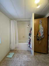 Bathroom featuring a textured ceiling, shower / tub combo, and tile patterned floors