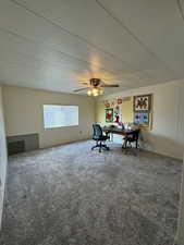 Interior space with a textured ceiling, carpet flooring, and a ceiling fan