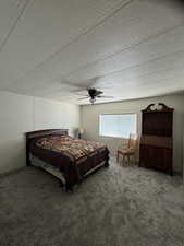 Carpeted bedroom with a ceiling fan and a textured ceiling