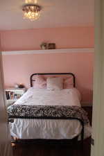 Bedroom featuring a chandelier and wood finished floors