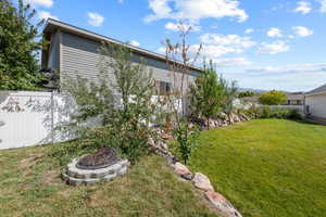 View of yard featuring fence and a fire pit