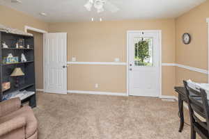 Sitting room with visible vents, baseboards, a ceiling fan, and light colored carpet