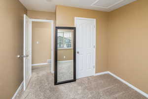 Unfurnished bedroom featuring baseboards, visible vents, and light colored carpet