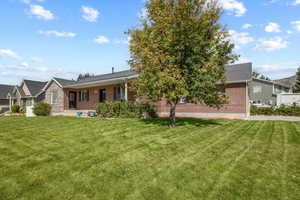 View of front of house featuring brick siding and a front lawn