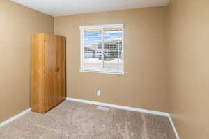 Unfurnished room with light carpet, baseboards, and visible vents