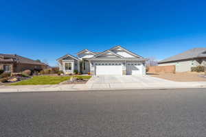 Craftsman inspired home featuring a garage, stone siding, board and batten siding, and concrete driveway