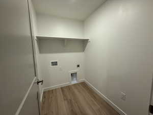 Laundry area with hookup for a washing machine, hookup for an electric dryer, laundry area, baseboards, and light wood finished floors