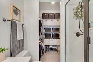 Full bathroom with toilet, a spacious closet, a shower with glass enclosure, and vanity