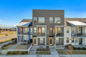 Townhome featuring brick siding, a mountain view, and a patio