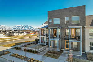 View of front of property featuring a residential view, brick siding, and a mountain view