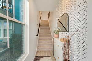 Entry way with natural light , stairs, and wood-like finished floors