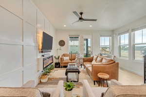 Sunroom featuring a glass covered fireplace and ceiling fan