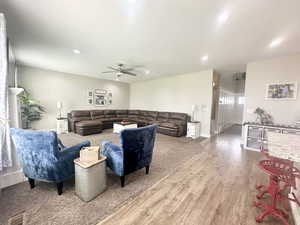 Living area with baseboards, visible vents, ceiling fan, wood finished floors, and recessed lighting