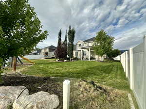 View of yard featuring a playground, a fenced backyard, and a residential view