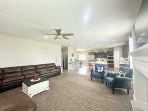 Carpeted living room with a textured ceiling, a ceiling fan, and recessed lighting