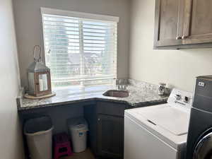 Laundry room with washing machine and dryer, a sink, and cabinet space