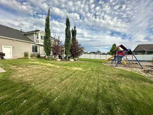 View of yard featuring a playground and a fenced backyard