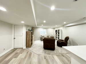 Living room with baseboards, wood finished floors, visible vents, and recessed lighting