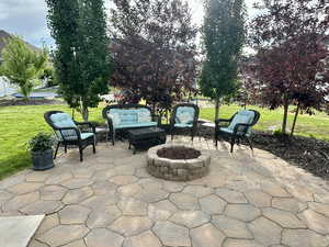 View of patio with an outdoor living space with a fire pit