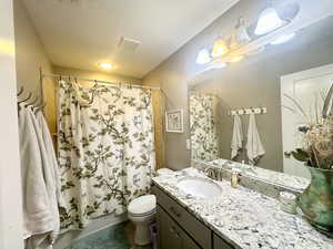 Full bathroom with shower / bath combination with curtain, visible vents, vanity, and toilet