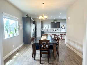 Dining room featuring a notable chandelier, dark wood finished floors, and baseboards