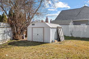 View of shed with a fenced backyard