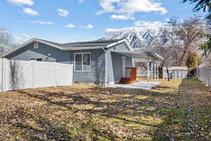 Exterior space with a fenced backyard, crawl space, a storage unit, a mountain view, and a carport