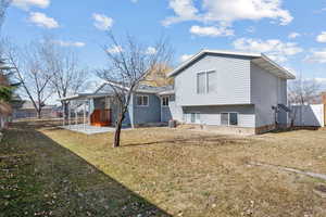 Back of property with a carport, fence, central AC, and a yard