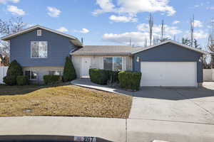 Tri-level home with brick siding, driveway, and an attached garage