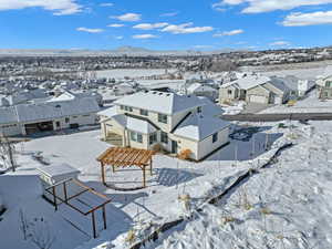 Snowy aerial view featuring a residential view and a mountain view