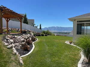 Fenced backyard featuring a pergola and a mountain view