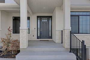 Doorway to property with stone siding and stucco siding