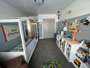 Recreation room featuring dark colored carpet