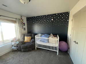 Bedroom with baseboards, visible vents, and carpet flooring