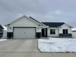 View of front of home with a garage, driveway, and board and batten siding