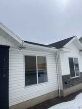 View of property exterior featuring a shingled roof and board and batten siding