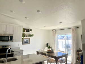 Dining area with vaulted ceiling and a textured ceiling