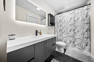 Full bath featuring toilet, tile patterned flooring, vanity, and shower / bathtub combination with curtain