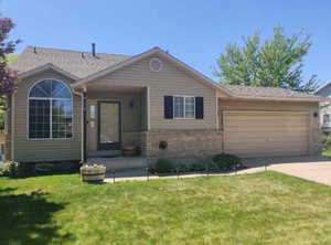 Ranch-style home with a garage, brick siding, and a front yard